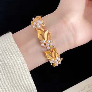 Nahaufnahme eines Vintage-Goldarmbands in Ährenform mit Perlen und Kristallen