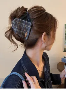 Side view showing the detailed plaid and leather texture of the retro hair claw clip worn on bun.