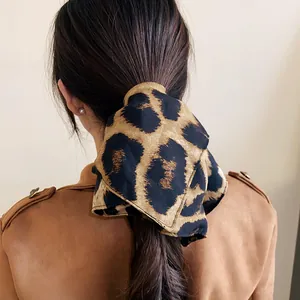 Dettaglio scrunchie plissettato leopardato stile Maillard su acconciatura a coda di cavallo