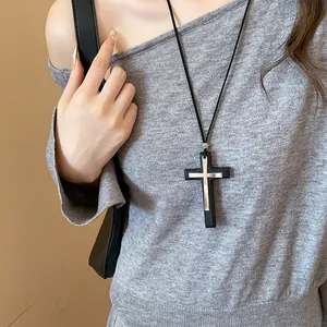 Retro gothic black and silver cross pendant necklace worn with a grey knit sweater