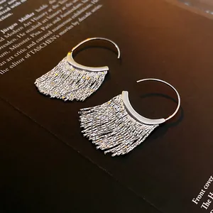 Detailed macro shot of elegant silver tassel earrings resting on a modern art book