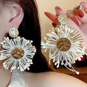 Bohemian style oversized white raffia flower earrings with hammered gold metal studs
