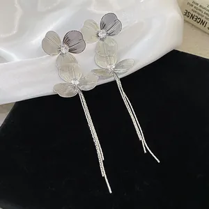 Detailed view of silver leaf tassel earrings with sparkling center stones on velvet