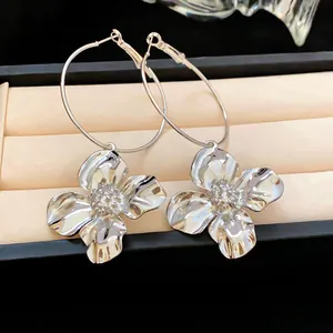 Elegant silver flower hoop earrings displayed in a luxury jewelry box detail view