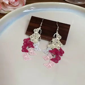 Detailed macro view of butterfly tassel earrings with colorful gradient metal filigree