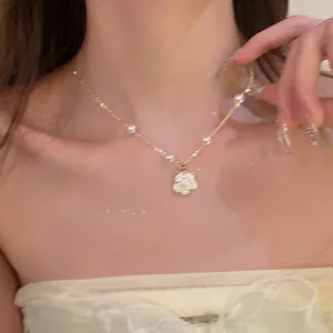 Elegante collana di perle con ciondolo a fiore di strass scintillanti su modella.