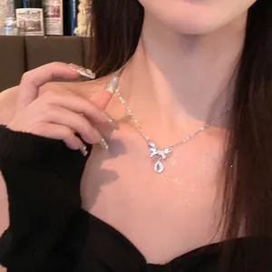 Dettaglio ravvicinato di una collana con ciondolo a fiocco scintillante indossata