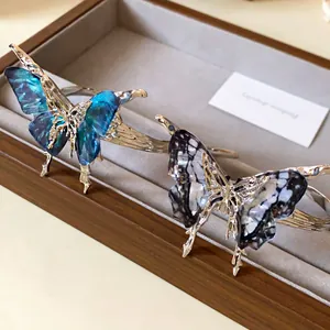 Close-up detail of stylish butterfly open cuff bracelets with liquid metal design
