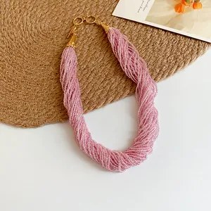 Primo piano di una collana di perline rosa a più fili con elegante chiusura a ginocchio