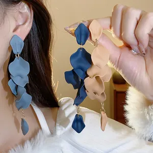 Primo piano di orecchini nappa petalo opaco in tonalità blu e beige.