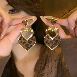 Gros plan de boucles d'oreilles cœur léopard rétro avec cadres dorés élégants