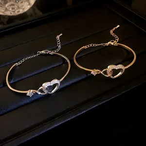 Elegant gold and silver zircon heart hollow bracelets displayed on black jewelry display tray