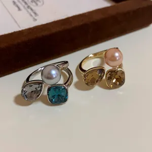 Close-up of vintage gold-plated rings featuring pearls and square crystals