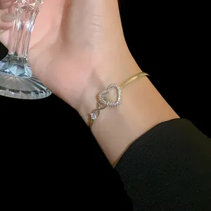 Detailed view of an elegant gold heart bracelet featuring sparkling zircon stones on wrist