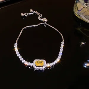 Silver-toned adjustable bracelet with a radiant yellow rectangular zircon center