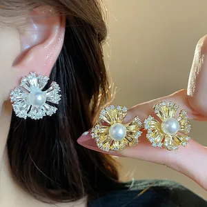 Detailed close-up showing 18k gold-plated flower earrings with pearls and zircons