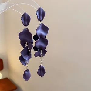 Primo piano dettagliato di orecchini con petali viola opachi e catene d'argento