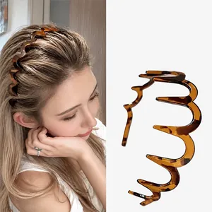 Gedetailleerd overzicht van een golvende haarband met tanden in schildpadmotief voor volume.