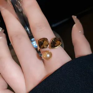 Detail shot of vintage gold-plated adjustable ring featuring a pearl and brown stones