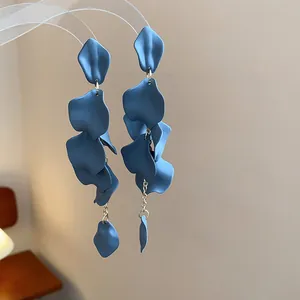 Dettaglio degli orecchini pendenti a petalo blu opaco con catenelle argentate