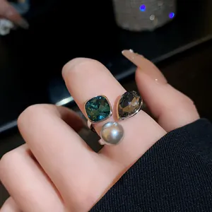 Close-up of vintage gold-plated open ring with pearl and crystals