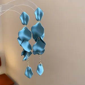 Dettaglio ravvicinato di orecchini vintage a petalo blu opaco con catenina d'argento fine