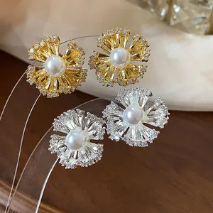 Close-up of elegant flower earrings with pearl centers and zircon petals.