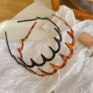 Detail van golvende getande haarbanden in zwart en amberkleurige schildpad afwerking