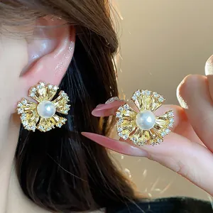 Close-up of elegant 18k gold plated flower earrings with pearl and zircon detail on ear