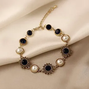 Close-up macro view of vintage gold-toned bracelet with blue gemstones and white pearls