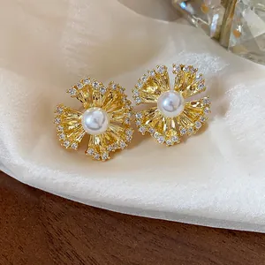 Detail view of gold-plated flower clip-on earrings with pearl center and crystals