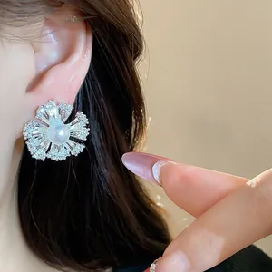 Close-up of elegant silver-tone flower earring with pearl and cubic zirconia stones