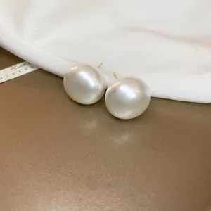 Primer plano detallado de pendientes de perlas blancas grandes sobre seda de lujo