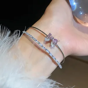 Elegant silver zircon bow and heart bracelet set for women shown close-up on wrist.