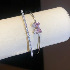 Close-up of elegant bow-knot bracelet with pink heart-shaped zircon stones