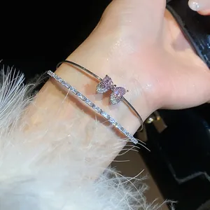 Close-up of zircon butterfly bracelet and crystal tennis bangle on wrist