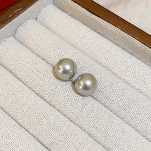 Primer plano detallado de elegantes pendientes de perlas grises con acabado brillante