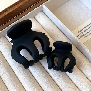 Set of two minimalist matte black wavy hair claw clips displayed in a jewelry box