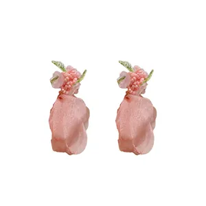 Eleganti orecchini a fiore in tulle rosa con perline e perni in argento.