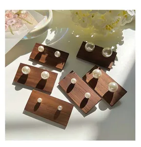 Close-up of elegant pearl stud earrings in various sizes on wooden display blocks