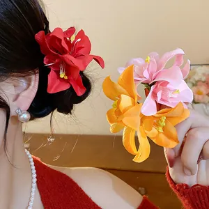 Gros plan de barrettes à fleurs en tissu coloré portées et tenues par un mannequin.