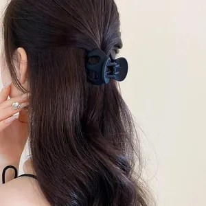 Detailed close-up view of a minimalist black matte wavy hair claw clip on long hair