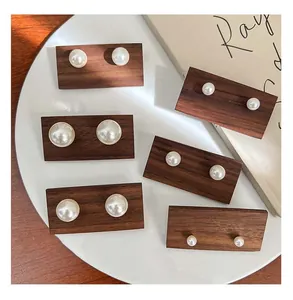 Detailed view of high-luster pearl stud earrings in various sizes with silver pins.