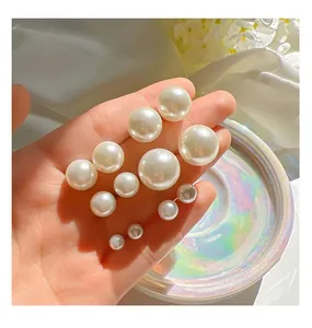 Detailed view of multiple sizes high-gloss white pearl stud earrings with silver needles