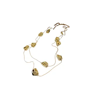 Long collier élégant à deux couches avec perles plissées dorées irrégulières sur blanc