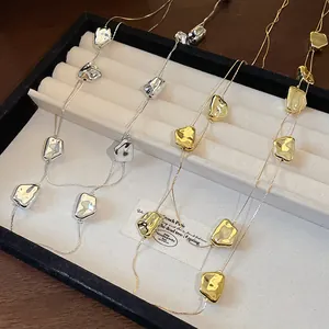 Gros plan de colliers double couche avec des perles froissées irrégulières dorées et argentées.