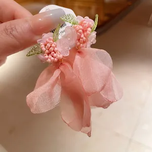 Vista dettagliata degli orecchini floreali rosa con petali in morbida rete mesh