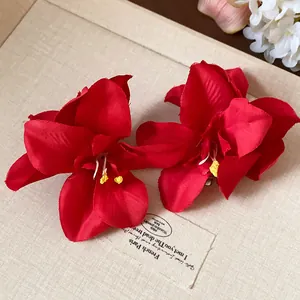 Détail d'une pince à cheveux fleur en tissu rouge avec une texture de pétale réaliste