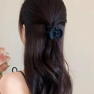 Matte black wave hair claw clip shown in an elegant half-up hairstyle detail shot