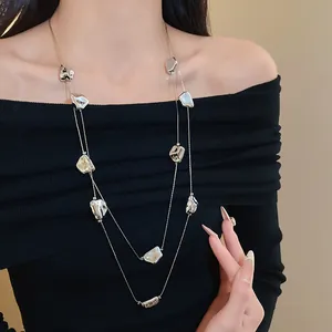 Détail d'un long collier double rang avec pendentifs plissés irréguliers sur mannequin